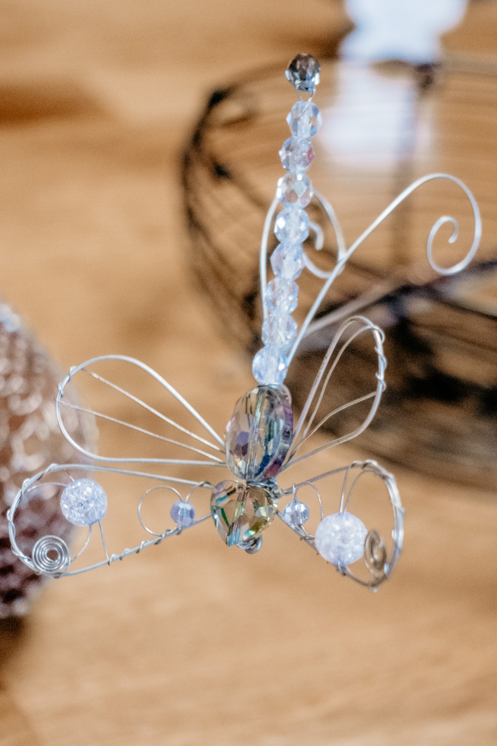 Drôtená vážka s korálkami, na stole, ktorú vytvorila drotárka Editka Homolová v creActive.
